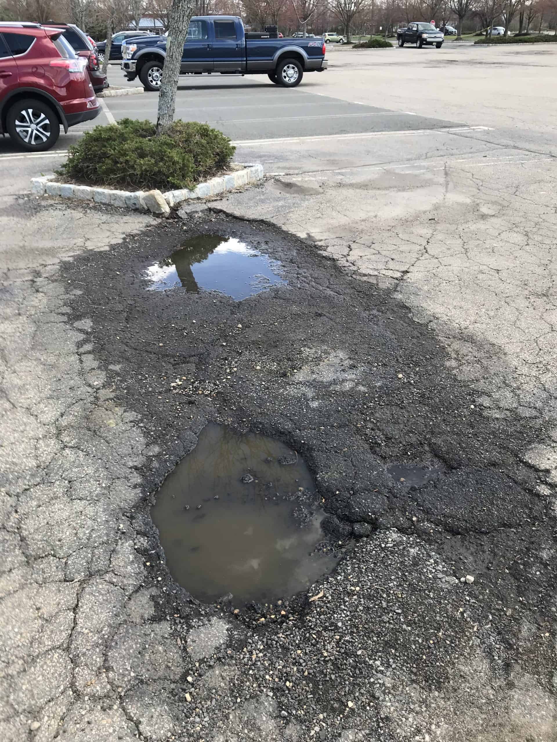 A professional crew repairing a pothole in a commercial parking lot in the Tri-State area to improve safety and extend pavement lifespan.