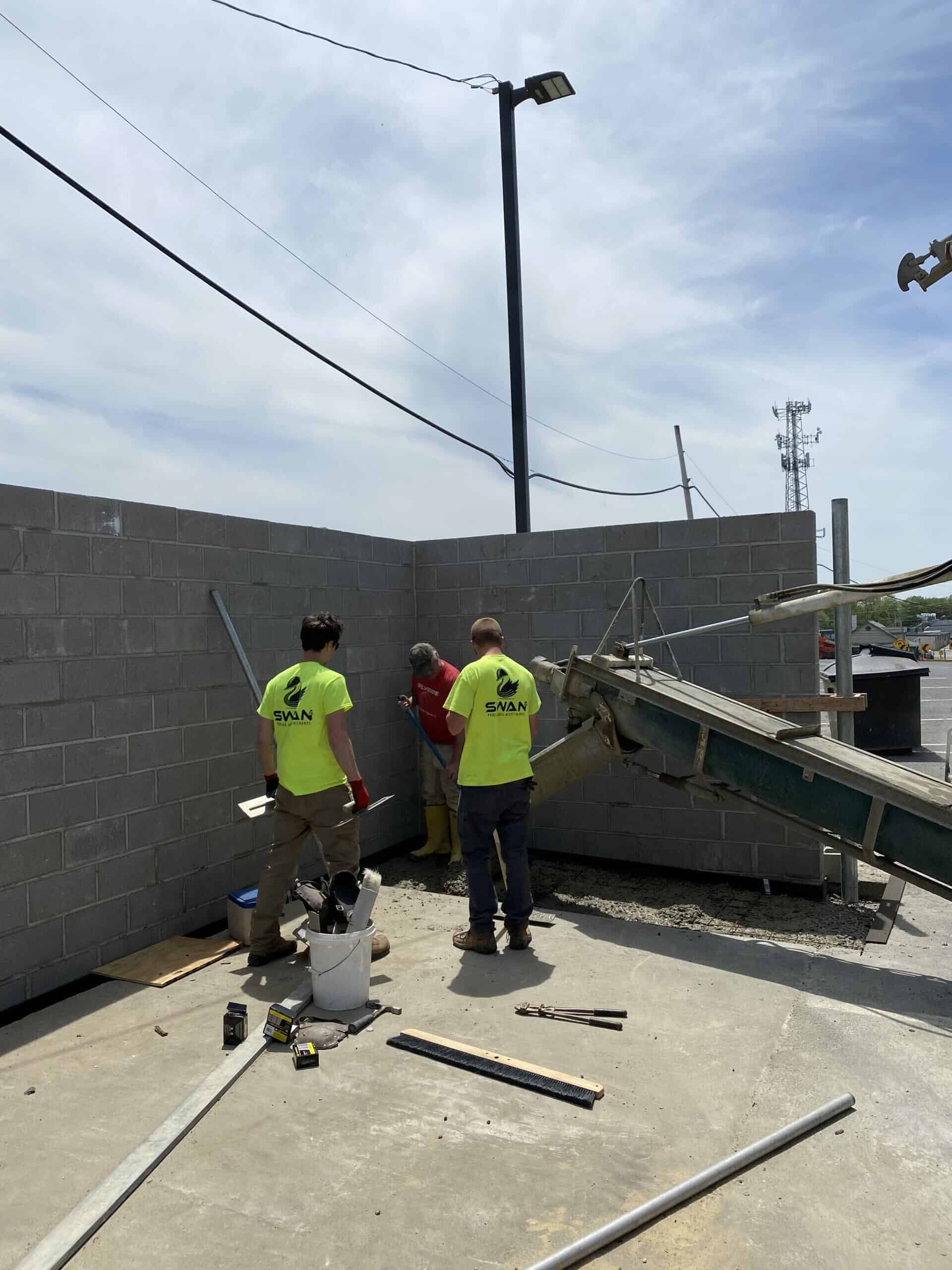A masonry dumpster enclosure being installed at a commercial property in the Tri-State area to improve security and property aesthetics.