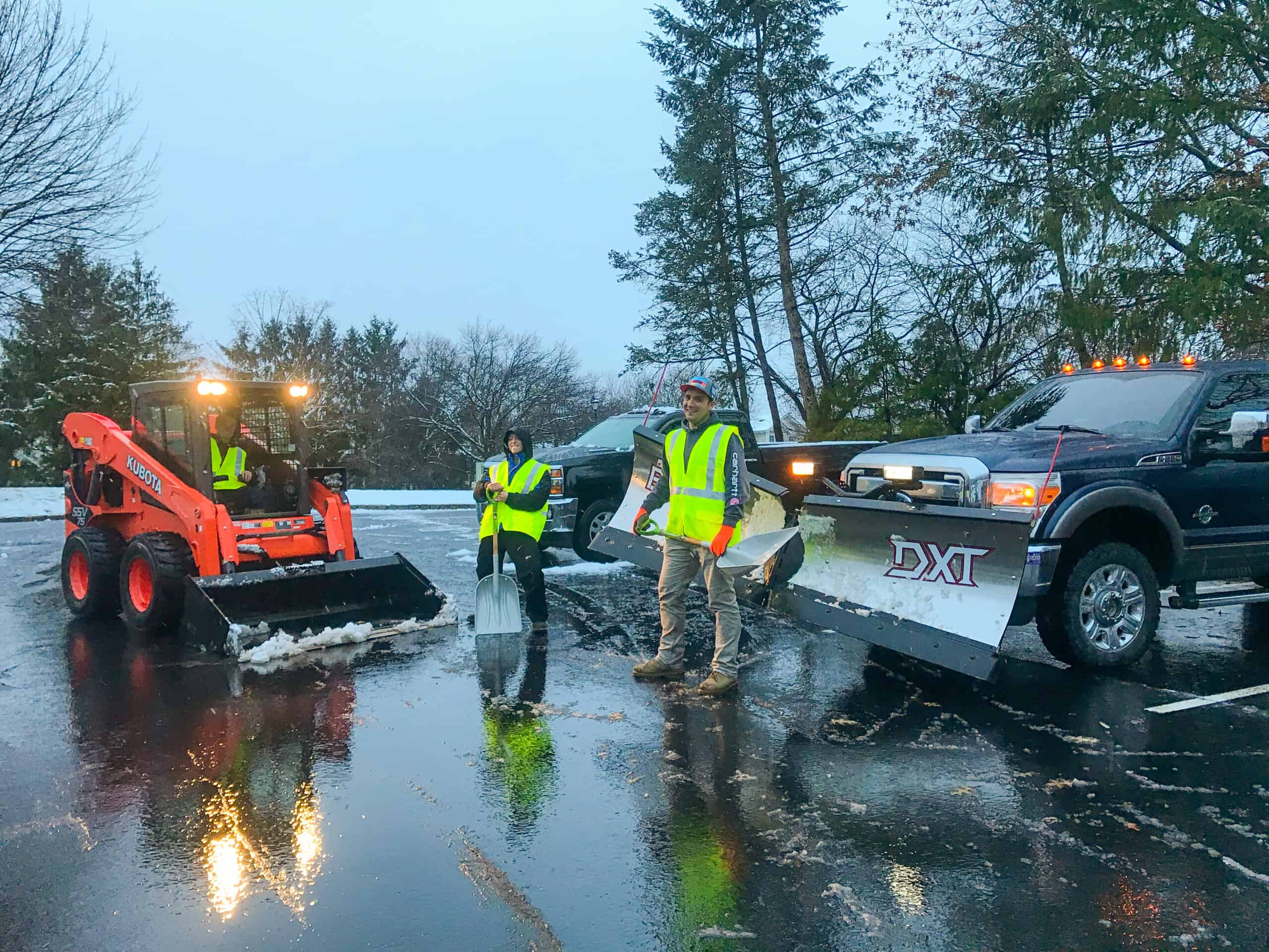 Professional crew applying de-icing treatments in a commercial parking lot to prevent slippery surfaces and ensure safe access for businesses in the Tri-State area.
