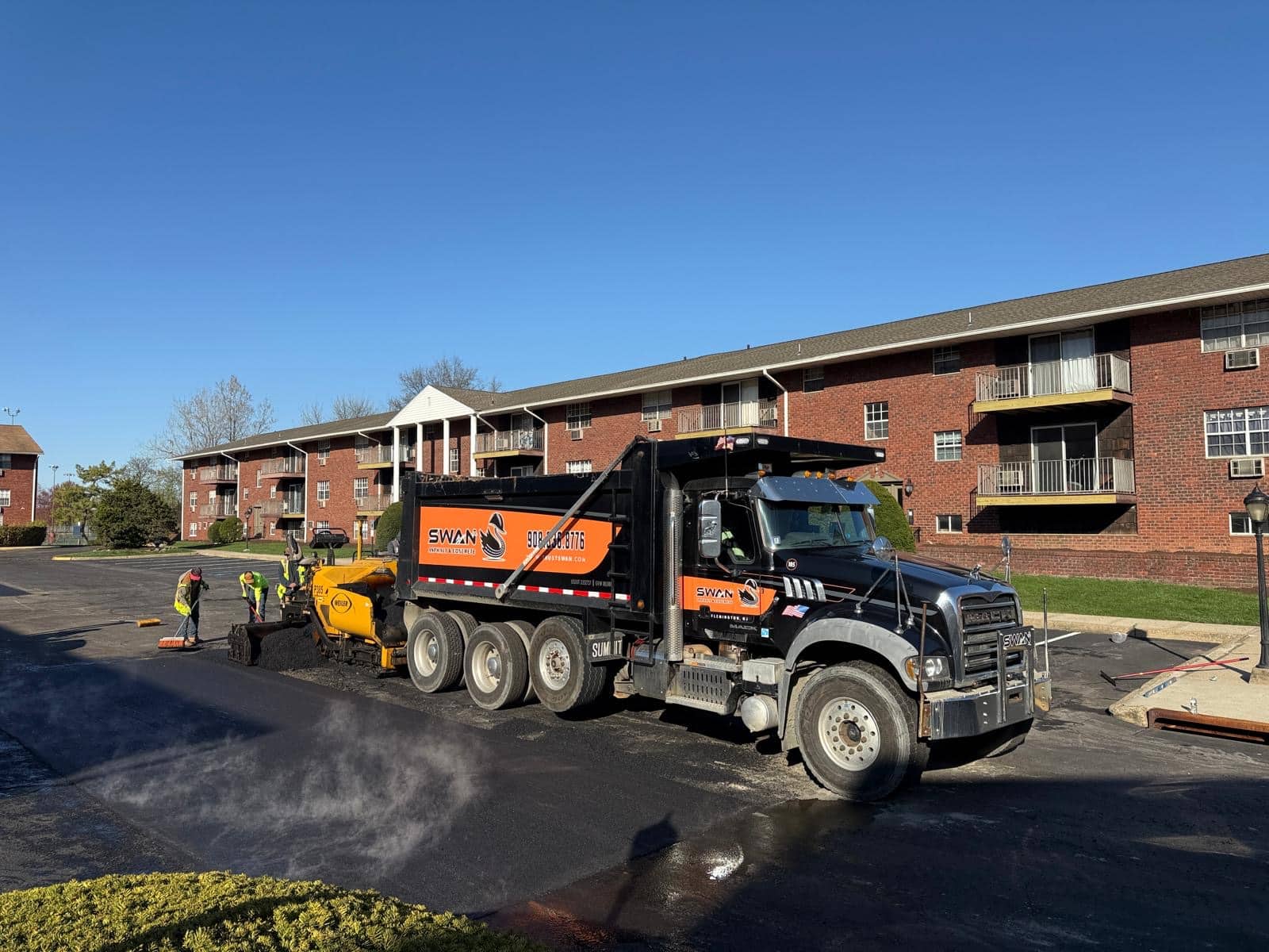 Swan Co. crew using a dump truck and paver to apply asphalt in Ridgefield Park, NJ.