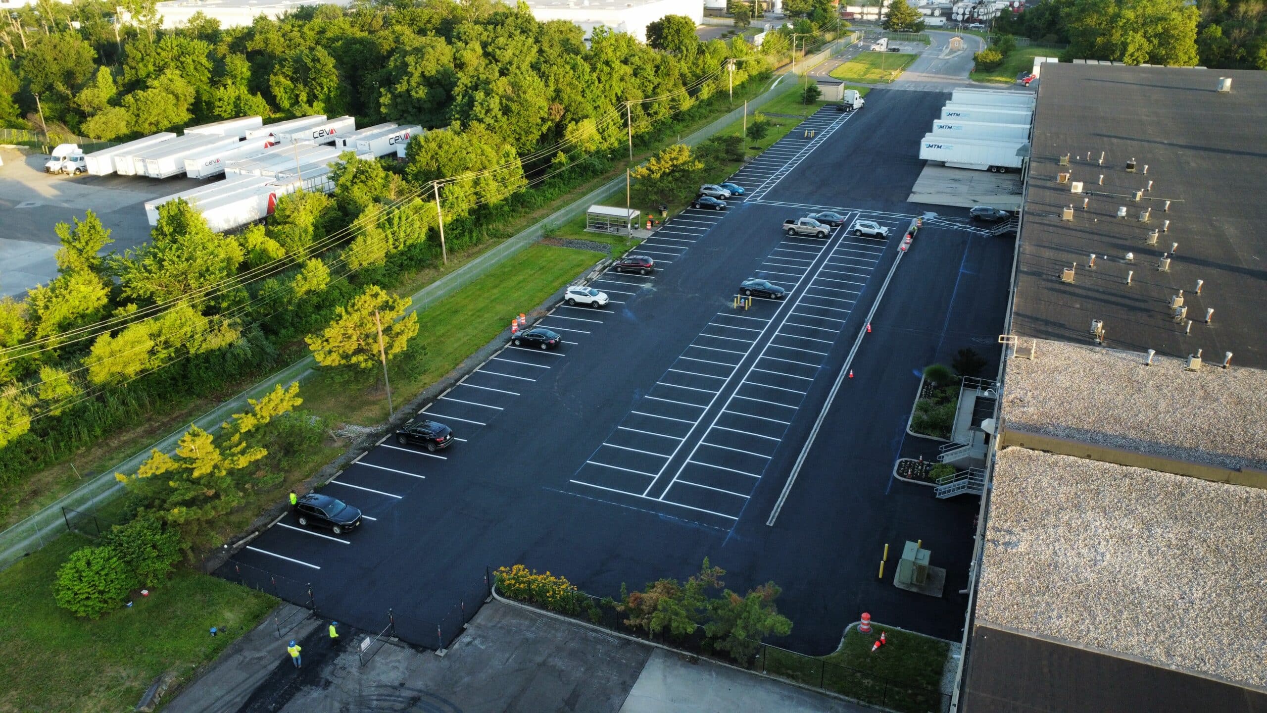 Overhead view of a completed commercial parking lot with new asphalt and clear markings.