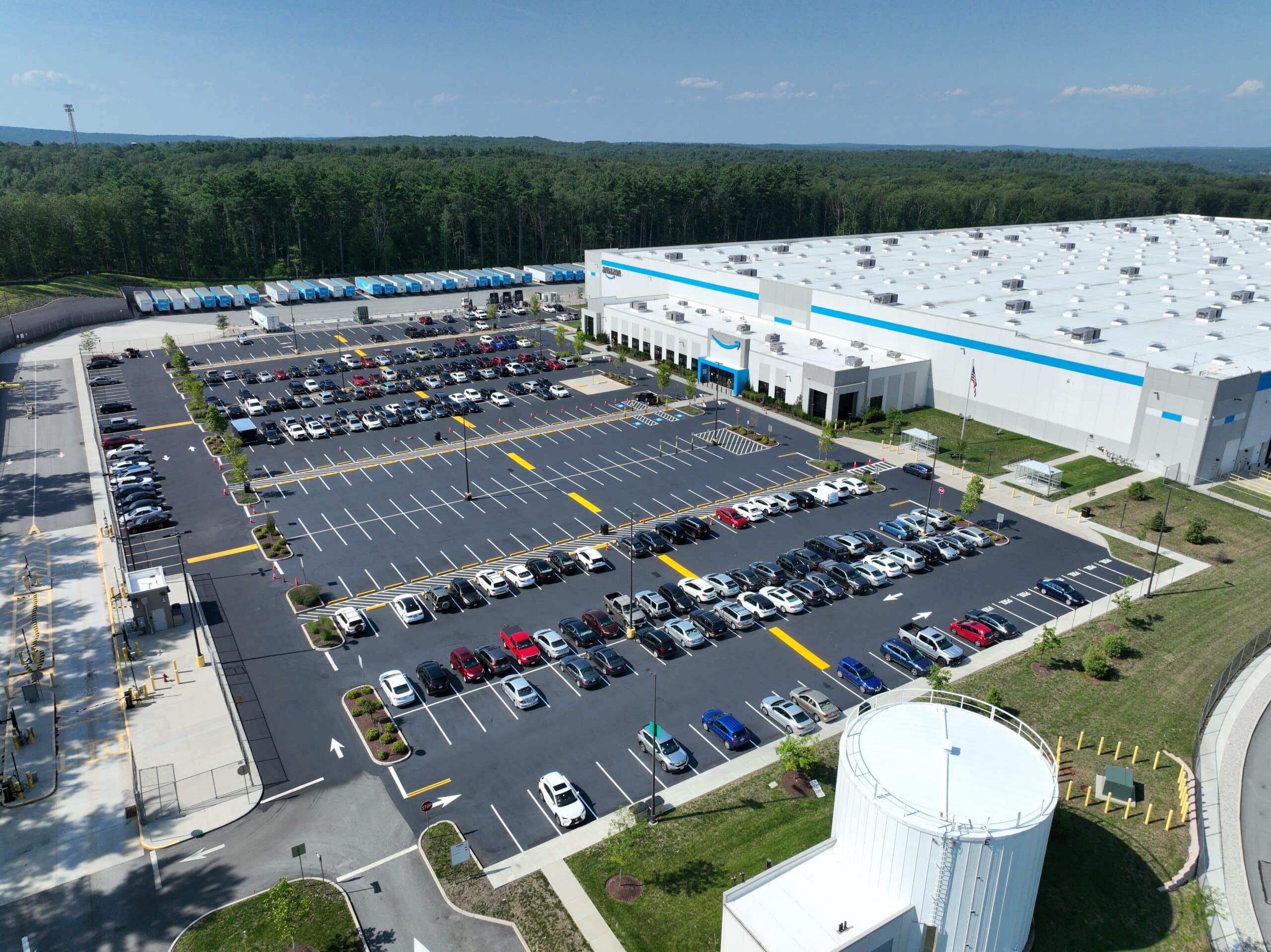 Aerial view of repaved and restriped parking lot at a busy Uxbridge, MA distribution facility, showing fresh asphalt and bright line striping.