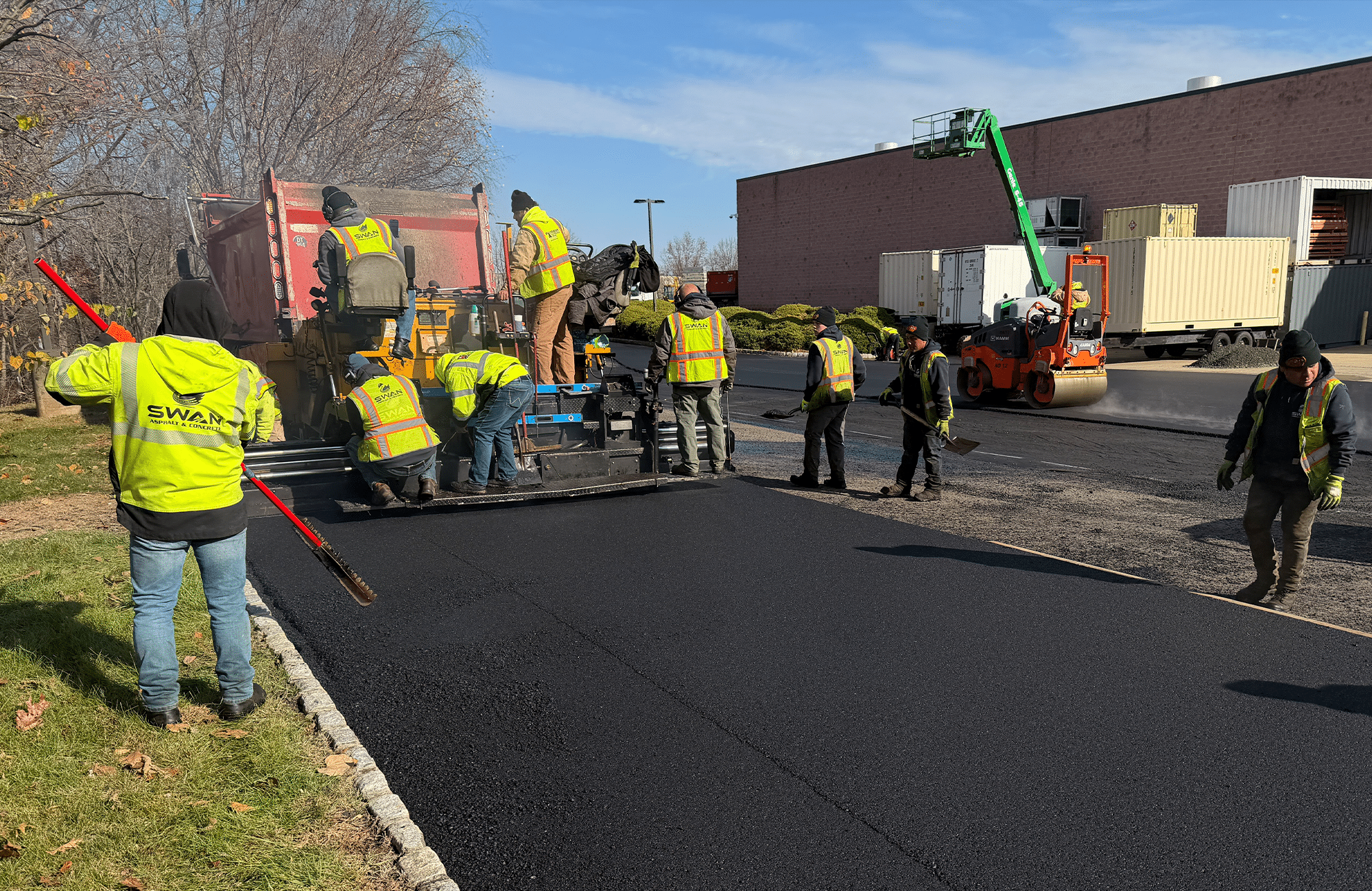 Asphalt paving crew installing fresh pavement with proper preparation and compaction.