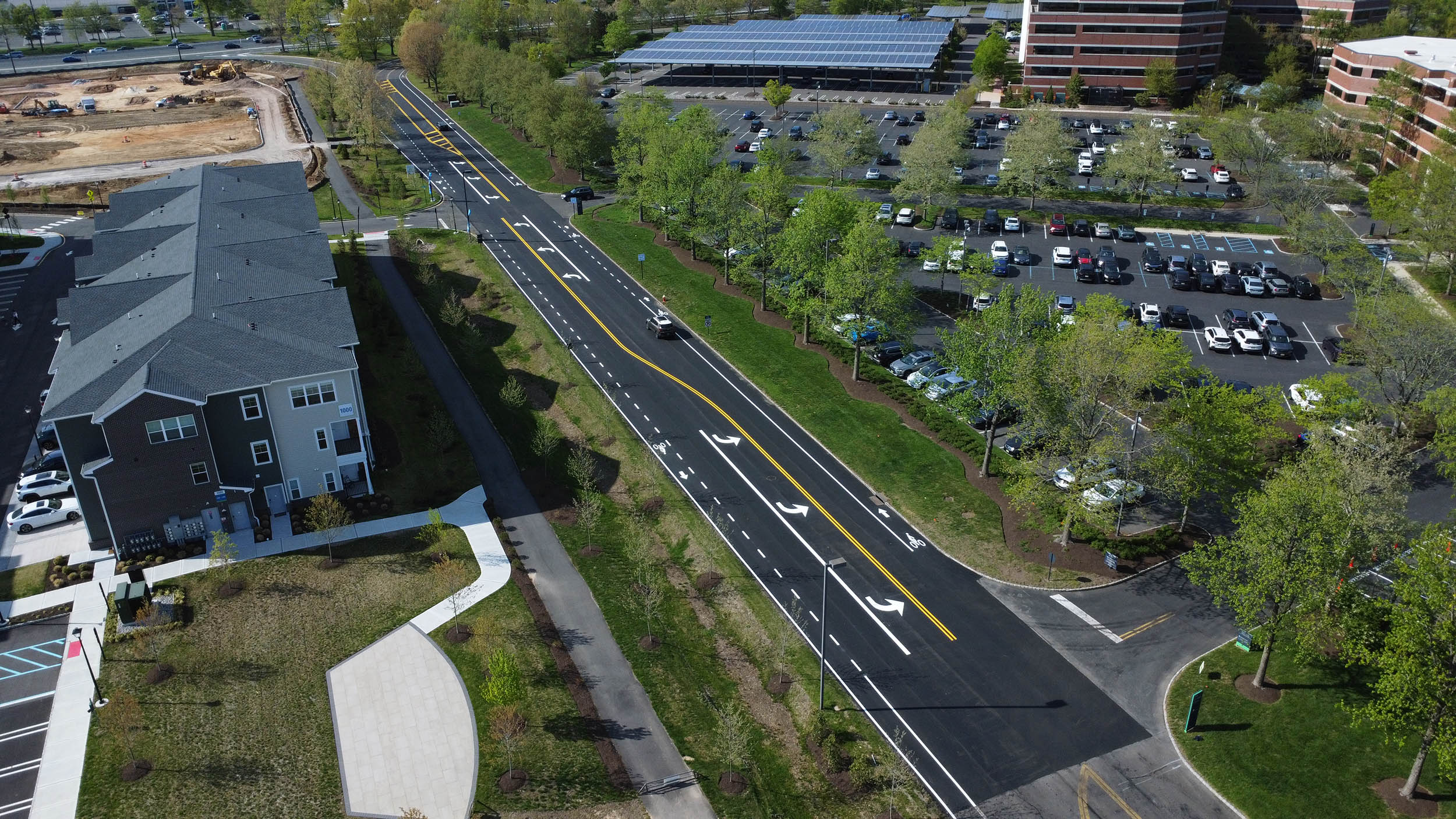 Aerial view of roadway paving and fresh line striping at BXP Carnegie Center, with parking lots and office buildings nearby.